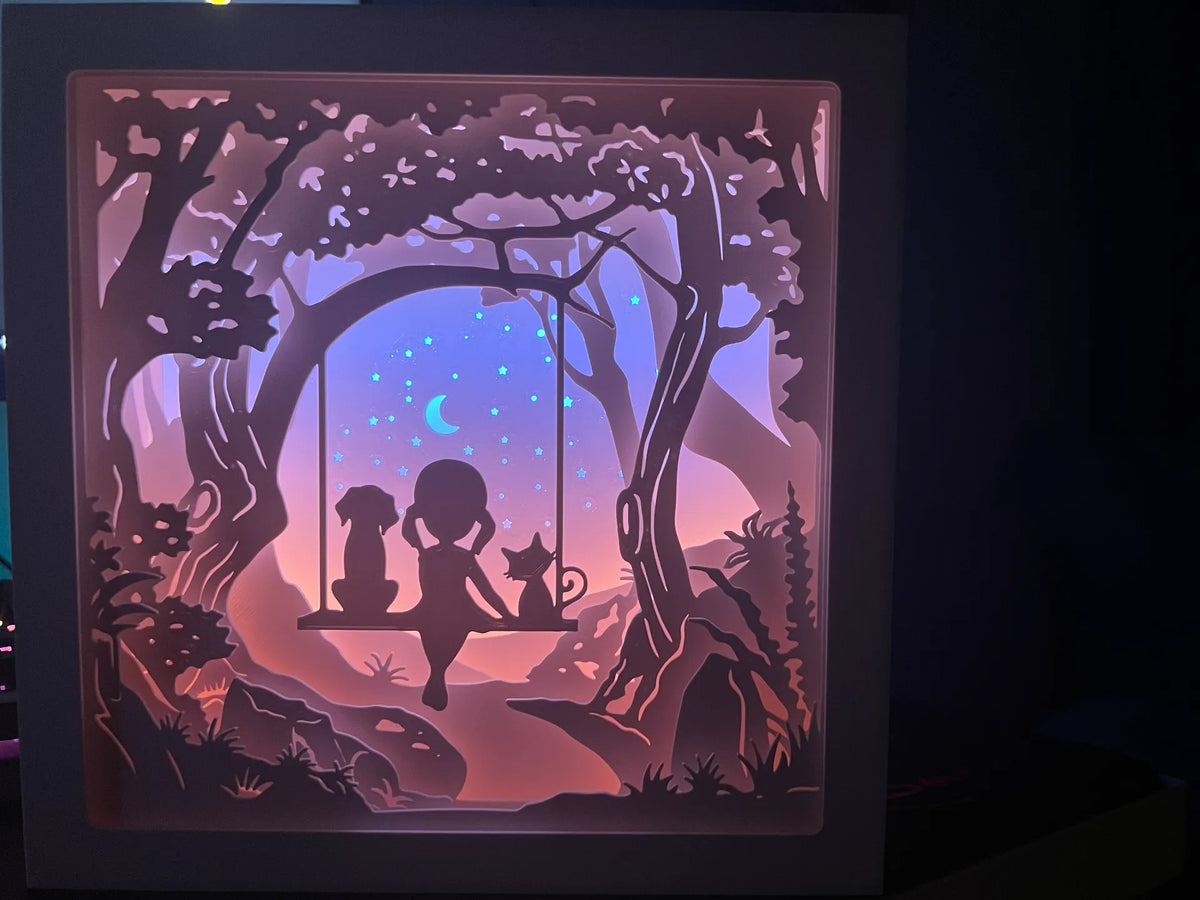 Fille avec un chat et un chien se balançant dans un arbre Shadowbox - Pet Print